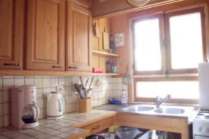 una cocina con armarios de madera y fregadero en Grand chalet vue montagne, en Saint-Pierre-de-Chartreuse