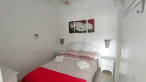 a small bedroom with a bed with a red blanket at Apartamento en Costacabana in El Alquián