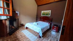 a bedroom with a bed and a fireplace at Chalés São Lázaro in São Bento do Sapucaí
