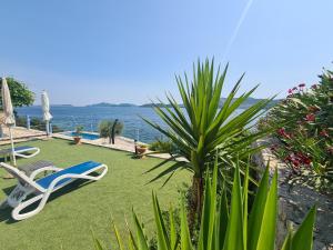 einen Garten mit Liegestühlen und Blick auf das Wasser in der Unterkunft Villa sea oasis Ratac in Slano