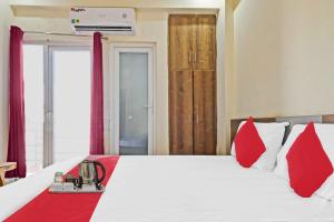 een slaapkamer met een groot bed met rode kussens bij OYO Star Residency Near Omaxe Gurgaon Mall in Gurgaon