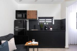 By Eezy - דירת נופש עם חדר שינה אחד במיקום מעולה Ashram 3 في إيلات: مطبخ مع ثلاجة سوداء وطاولة