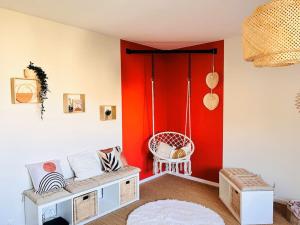 a living room with a couch and a red wall at Le Bobohème - Wifi - Parking in Royat