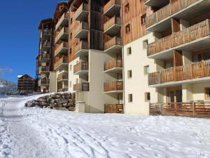 a snow covered street in front of a building at Logement au pied des pistes Superdevoluy in Le Dévoluy