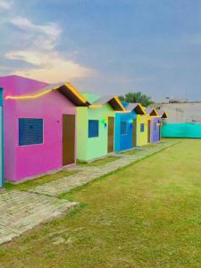a row of colorful houses sitting on top of a field at OYO Hotel Rosewood in Palwal