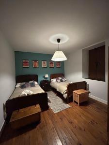 a bedroom with two beds and a living room at CASA LA BIERA in La Velilla