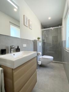 a bathroom with a sink and a shower and a toilet at QT Apartments Detmold in Detmold