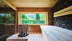 sauna con ventana grande y suelo de madera en Chata West Spazio en Prostřední Bečva