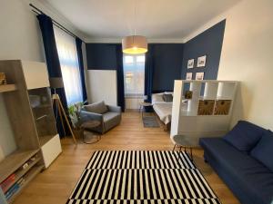 耶维克Błękitne Studio的客厅拥有蓝色的墙壁,配有沙发和椅子