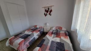 two beds sitting next to each other in a bedroom at Apartamentos La Goleta 1 in Denia