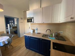 a kitchen with white cabinets and a sink and a table at Błękitne Studio in Żywiec