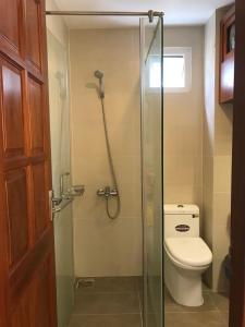 a bathroom with a toilet and a glass shower stall at Khách Sạn Blue Sky in Xã Thang Tam