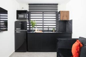 a kitchen with a black refrigerator and a sink at By Eezy - דירת נופש עם חדר שינה אחד במיקום מעולה Ashram 4 in Eilat