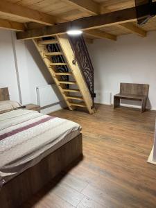 a bedroom with a bed and a wooden stairs at Wineyards Salin in Turda