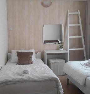 1 dormitorio con cama, escalera y TV en Apartmani Nis, en Niš
