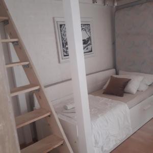 Apartmani Nis في نيشْ: غرفة نوم صغيرة بها سرير وسلم