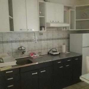 una cucina con armadi bianchi e lavandino di Apartmani Nis a Niš