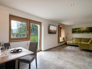 a living room with a table and a couch at Bergpanorama Kössen in Kössen