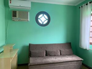 - un canapé dans une chambre dotée d'un mur bleu dans l'établissement Ap Família no Estreito, à Florianópolis