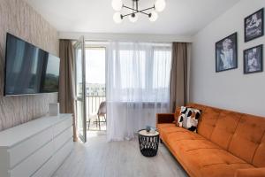 un soggiorno con divano e una grande finestra di Hello Apartments Pomorska z widokiem na morze a Danzica
