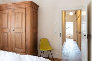 Una silla amarilla en una habitación con dormitorio en Palais Wunderlich, en Lahr
