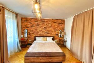 um quarto com uma cama grande e uma parede de tijolos em City Center Bed and Beyond em Bucareste