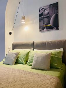 a bed with green and white pillows on it at Via Caputo 51 in Grottaglie