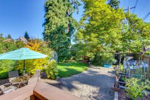 a backyard with a table and an umbrella at Charming Eugene Vacation Home 1 Mi to Dtwn! in Eugene