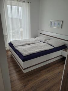 een bed in een witte kamer met een groot raam bij Apartament Sunrise Poznań - Self Check-in 24h in Poznań
