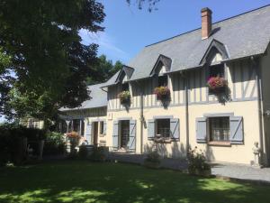 a white house with flower boxes on the windows at Chambres et Table d'Hôtes du Coquerel in Saint-Siméon