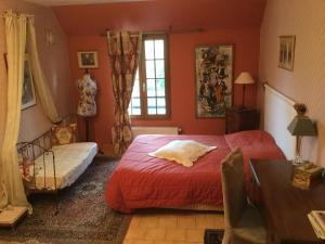 a bedroom with a red bed and a window at Chambres et Table d'Hôtes du Coquerel in Saint-Siméon