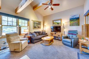 a living room with a couch chairs and a tv at Historic Colorado Springs Home with Yard in Downtown in Colorado Springs