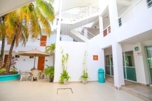 a courtyard in a building with a table and chairs and palm trees at Terracaribe Hotel Boutique in Cancún