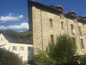 un gran edificio de piedra junto a un edificio blanco en Casa Baratech 2C en Biescas