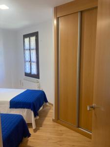 una camera con due letti e una porta scorrevole in vetro di Casa Baratech 2C a Biescas