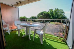 uma mesa e cadeiras numa varanda com vista em Studio cabine + Parking : proche plage em Canet-en-Roussillon