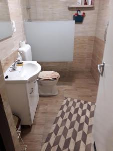 łazienka z białą umywalką i toaletą w obiekcie Kelemen Apartmanok w Abádszalók
