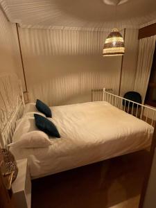 a bedroom with a white bed with blue pillows at La Santina y su Jardín in Avilés +10 photos
