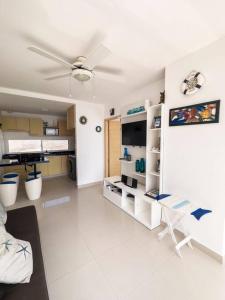 een woonkamer met een plafondventilator en een witte vloer bij Dpto frente al mar, piscina, check in automático in Playas