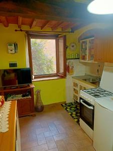 una cucina con piano cottura e una finestra di La Fontanella a Castagneto Carducci
