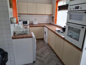 cocina con fregadero y fogones horno superior en Deluxe Double bedroom with private bathroom, parking and WiFi en Leeds