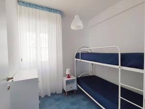 1 dormitorio con 2 literas y ventana en Ville Agnuli Case Vacanza, en Mattinata
