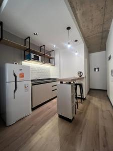 a kitchen with white appliances and a wooden floor at Cozy Home Salta in Salta