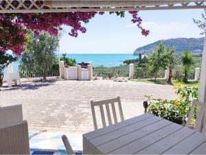 un patio con mesa, sillas y el océano en Ville Agnuli Case Vacanza, en Mattinata
