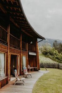 a house with two chairs on a wooden deck at CHALET D'ERT in La Valle