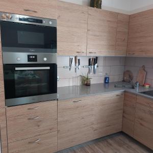 a kitchen with wooden cabinets and a microwave oven at U domečku s keramikou in Karlovy Vary