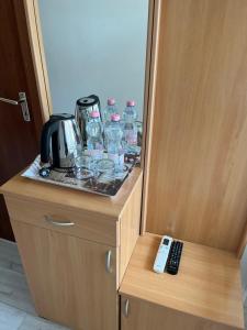 a cabinet with water glasses and a remote control at Tang house 唐舍 in Budapest
