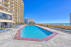 a swimming pool next to a building with chairs at Phoenix V 614 in Orange Beach