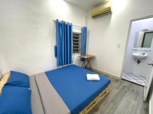 a bedroom with a blue bed and a sink at Enjoy Homestay in Ho Chi Minh City