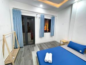 a bedroom with a blue bed and blue curtains at Enjoy Homestay in Ho Chi Minh City